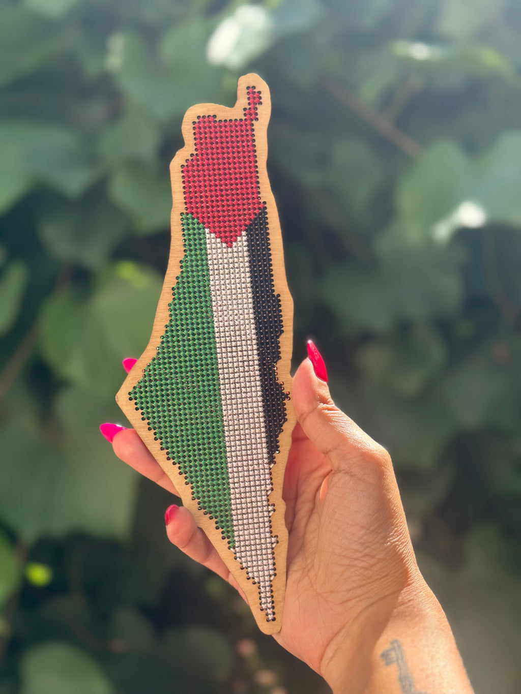 completed tatreez stitchable palestine map in hand